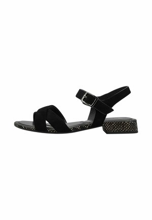 Black suede sandal with crisscross straps and a buckled ankle strap. Features a textured, decorative block heel and smooth, cushioned footbed.