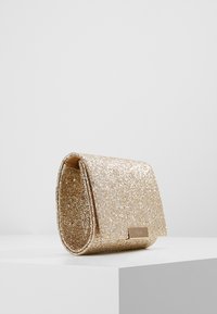 Glittery gold clutch bag with a smooth texture, rectangular shape, and a metal logo accent on the front. Compact design, minimal hardware.