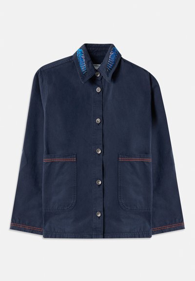 Σακάκι ναυτικού μπλε με κουμπιά και μακριά μανίκια, δύο μπροστινές τσέπες με πορτοκαλί ραφές, και γιακά με μπλε κεντημένα σχέδια φύλλων.