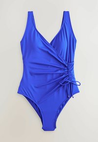 Maillot de bain une pièce bleu en tissu lisse avec un décolleté plongeant, un design enveloppant, un côté froncé avec un détail en corde et des accents dorés.