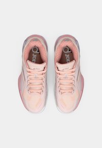 Svetlo roza atletski čevlji z teksturiranim mrežastim zgornjim delom, ravnimi vezalkami in rožnato gumijasto podplatom. Imajo subtilne geometrijske vzorce in logotip.