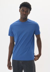 Camiseta de manga corta azul en una suave mezcla de algodón, con escote redondo y un corte relajado. Sin patrones ni acentos visibles.
