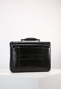 Valigetta in pelle nera con un design strutturato, caratterizzata da dettagli blu, una maniglia superiore e numerose tasche esterne per l'organizzazione.