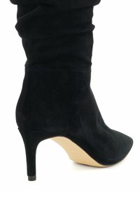Black suede ankle boot with a pointed toe, high stiletto heel, and gathered texture detailing along the shaft, featuring a beige sole.