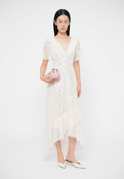 Rochie midi albă cu paiete, cu decolteu în V, mâneci ușoare transparente și tiv cu volane stratificate. Asortată cu un clutch roz pal și mule ascuțite.