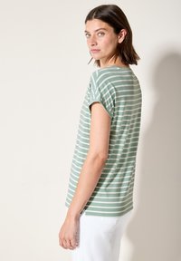 T-shirt à manches courtes rayé en vert et blanc, fabriqué en tissu doux, avec une coupe décontractée et un col rond. Aucun accent particulier.