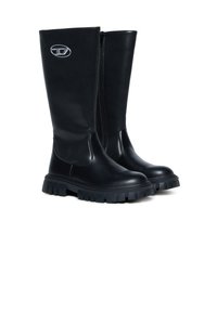 Juodi fekaliniai batus su masyviais padais, lygaus odos priekiu, matinės medžiagos nugara, šoniniu užtrauktuku ir sidabriniu ovalo formos logotipu arti viršaus.