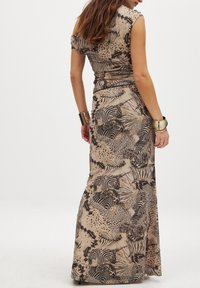 Abito maxi in tessuto beige con stampa di motivi animali neri. Presenta maniche a cappuccio e una vita aderente, che si allarga in una gonna ampia.