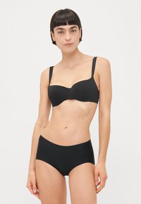 Soutien-gorge de bikini noir avec des bonnets lisses et des bretelles réglables, associé à un bas de bikini taille haute assorti. Les deux présentent une finition élégante.