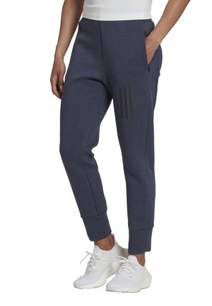 Marina blå sweatpants med en figursydd design, ribbade ärmslut, sidofickor och tre svarta ränder på vänstra låret. Tillverkad av mjukt material.