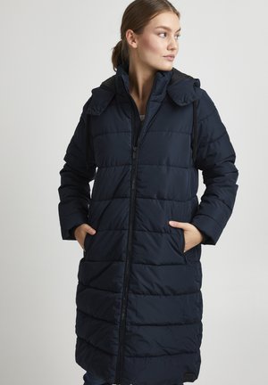Manteau rembourré bleu marine avec fermeture éclair à l'avant, capuche et deux poches latérales. Présente un design matelassé avec des coutures horizontales pour l'isolation.