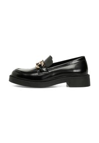 Loafer en cuir noir avec un bout arrondi, une boucle dorée décorative et une semelle noire épaisse. Présente une texture lisse et des coutures détaillées.