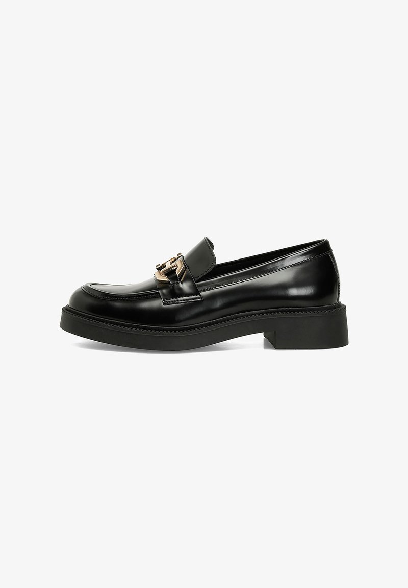 Black leather loafer with a rounded toe, a decorative gold buckle, and a chunky black sole. Features smooth texture and detailed stitching.