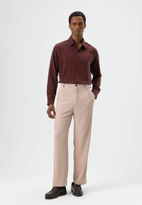 Dieprode blouse met lange mouwen en knopen, beige broek met fijne strepen en bruine loafers. Glad stof met een getailleerde pasvorm en strakke lijnen.