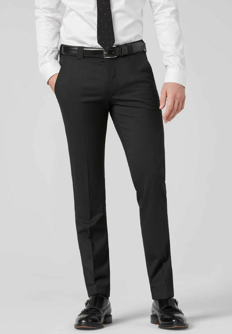 Zwarte dress pants met een slim fit, gemaakt van een gladde stof, met een platte voorkant, riemlussen en scherpe plooidetails. Gecombineerd met zwarte schoenen.