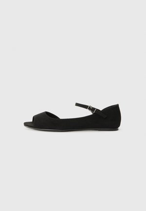 Sandal preto de camurça com a ponta aberta, tira no tornozelo e sola plana. Textura suave, design minimalista e forma arredondada.