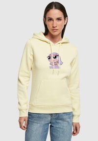 Gul bomullshoodie med snorer, frontlomme, med grafikk av en tegnfigur med store øyne og tekst under.