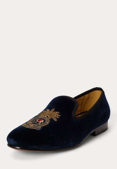 Nadmorsko modri žametni natikač z črnim robom in zlatim vezenim grbom s podobo palme in latinskim napisom na sprednji strani.