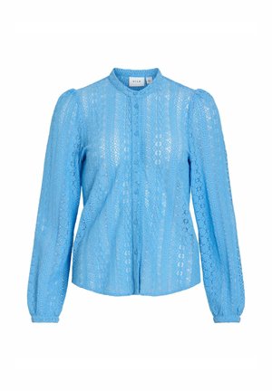 Blouse en dentelle bleu clair à manches longues, col montant, boutonnage devant et épaules légèrement bouffantes.