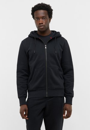 Black zip-up hoodie with a drawstring hood, featuring front pockets, ribbed cuffs, and a relaxed fit, made from soft, textured cotton.