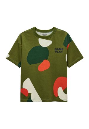 T-shirt manches courtes vert olive avec des formes abstraites vertes, rouges et blanches et le texte « GAME PLAY » sur la poitrine.