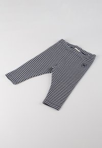 Leggings a righe in blu navy e bianco, realizzati in tessuto morbido, caratterizzati da un design aderente e una vita elastica con dettaglio del logo.