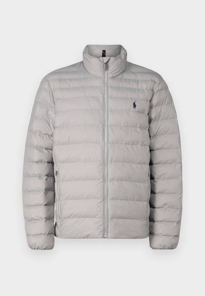 Lys grå pufferjakke med stående krage, horisontalt quiltet design, frontglidelås og liten brodert logo på venstre bryst.