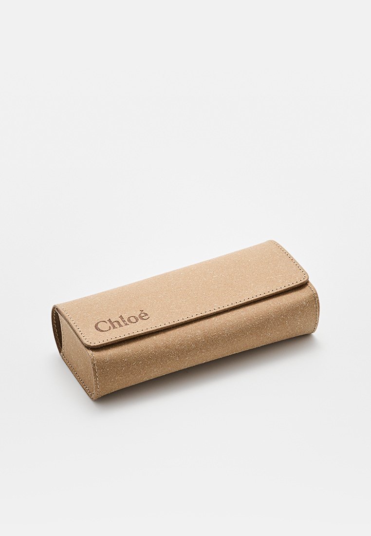 Jasnobrązowe prostokątne etui na okulary z teksturowanym wykończeniem, z klapką i tłoczonym logo. Gładkie krawędzie, minimalistyczny design.