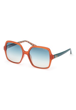 Kwadratowe okulary przeciwsłoneczne z pomarańczowymi przezroczystymi oprawkami, gradientowymi niebieskimi soczewkami oraz wzorzystymi zausznikami w niebiesko-pomarańczowy wzór. Zawierają detal logo na zausznikach.