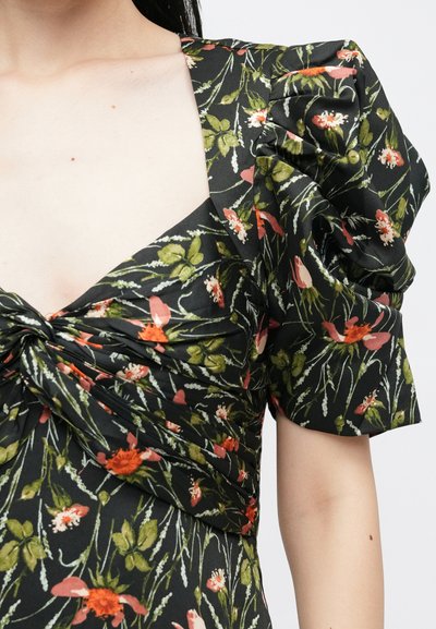 Robe noire à motifs floraux avec manches bouffantes, tissu froncé et décolleté en V profond. Le design présente des détails floraux rouges et verts sur un fond sombre.