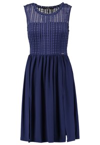 Navy-Kleid mit einem gemusterten Spitzen-Oberteil und einem fließenden Rock. Es hat einen runden Ausschnitt und Seitenschlitze für eine leichte Beweglichkeit.