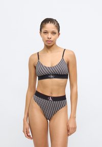 Σετ εσωρούχων από βαμβακερό μείγμα σε ασπρόμαυρο χρώμα, με σουτιέν με λεπτές τιράντες και σλιπ με ψηλή μέση, και τα δύο με μοτίβα λογότυπου και ελαστικές ζώνες.