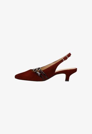 Czerwony zamszowy but na odkrytej pięcie z wydłużonym noskiem, z dwiema błyszczącymi paskami ozdobionymi klamrami oraz skromnym obcasem.