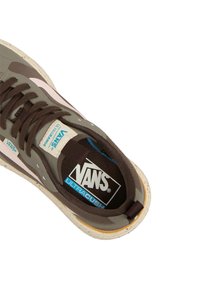 Zapatilla marrón con una parte superior texturizada, que presenta acentos en rosa y una mediasuela blanca manchada. Incluye un logo azul y negro en la plantilla.