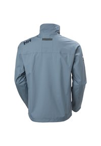 Světle modrá voděodolná bunda s dlouhými rukávy, vysokým límcem a černým logem "HH" na horní části zad na levém rameni.