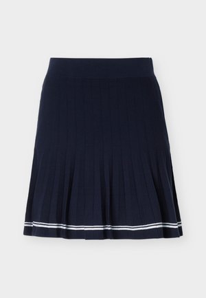 Φούστα σε σκούρο μπλε χρώμα με πιέτες, με φαρδιά ζώνη και δύο λευκές ρίγες κοντά στο στρίφωμα, σε απλό ανοιχτό φόντο.