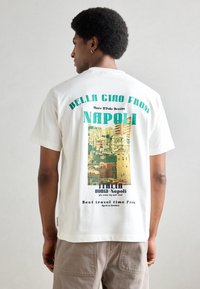 Witte katoenen t-shirt met een kleurrijk grafisch ontwerp van Napels met tekst. Korte mouwen en een relaxte pasvorm, gezien van de achterkant.