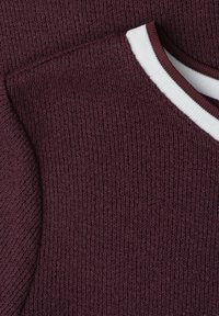 Gros plan d'un pull en maille bordeaux avec un col rond côtelé rayé blanc et bordeaux.