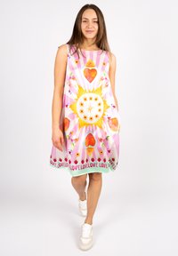 Farbenfrohes ärmelloses Kleid mit einem hellen Sonnenmuster, Herzen und floralen Akzenten. Hergestellt aus leichtem Stoff, knielang mit lässiger Passform.