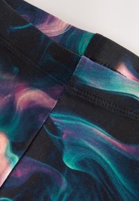 Fekete szövet, amelyen lila, türkiz és zöld színekből álló örvénymintázat látható. Látható varrások a varratok mentén. A textúra simának tűnik.