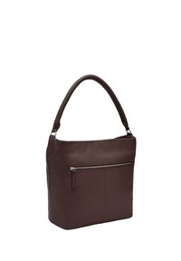 Brązowa skórzana torba o gładkiej fakturze, zaokrąglonym uchwycie i przedniej kieszeni na zamek. Charakteryzuje się minimalistycznym designem i czystymi liniami.