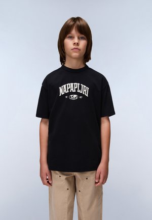 Melna kokvilnas t-kreklu ar "NAPAPIJRI" logo balta krāsā, īsām piedurknēm, apaļš izgriezums, saskaņots ar gaiši bežām biksēm ar spiņa detaļām.