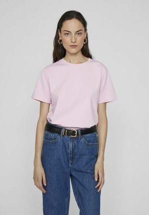 Lyserosa bomull T-skjorte med korte ermer, rund hals, paret med høy midje blå denimjeans og et svart belte med gullfarget spenne.