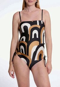 Én-delt badedrakt med et svart, hvitt og brunt bølgemønster. Har spaghettistropper og justerbar siderykking for passer.