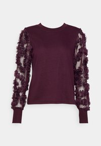 Viininpunainen pitkähihainen paita, jossa on yksivärinen runko ja läpikuultavat hihat, joita koristavat kolmiulotteiset kukka-applikaatiot. Hihat on viimeistelty resorireunuksilla.