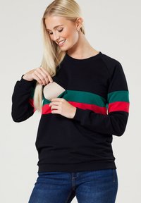 Schwarzer Sweatshirt mit grünen und roten horizontalen Streifen. Verfügt über einen seitlichen Reißverschluss für einen einfachen Zugang, gerippte Bündchen und einen entspannten Schnitt.