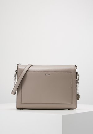 Sac bandoulière rectangulaire en cuir taupe avec poche avant, sangle ajustable, détail chaîne argentée et petit charm logo en métal.