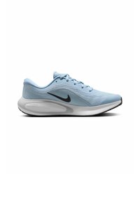 Zapatilla deportiva de color azul claro con una parte superior de malla texturizada, logo de Nike en negro, cuello acolchado y una entresuela blanca con una suela negra.