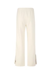 Wide-leg pants in cream with an elastic waistband, side slits at the hem, and a smooth, soft texture. Minimalist design with no visible patterns.