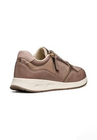 Zapatilla de cuero marrón con acentos en beige, puntera redonda, cuello acolchado, cremallera decorativa y suela clara en contraste, con recortes geométricos.